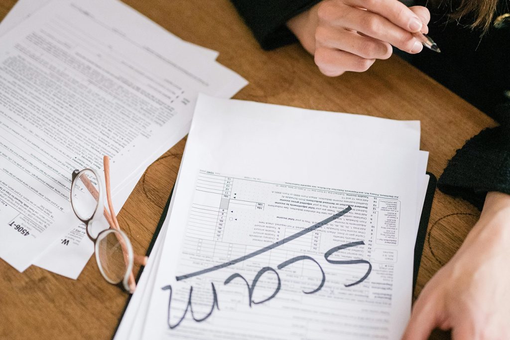 papers with the word SCAM across